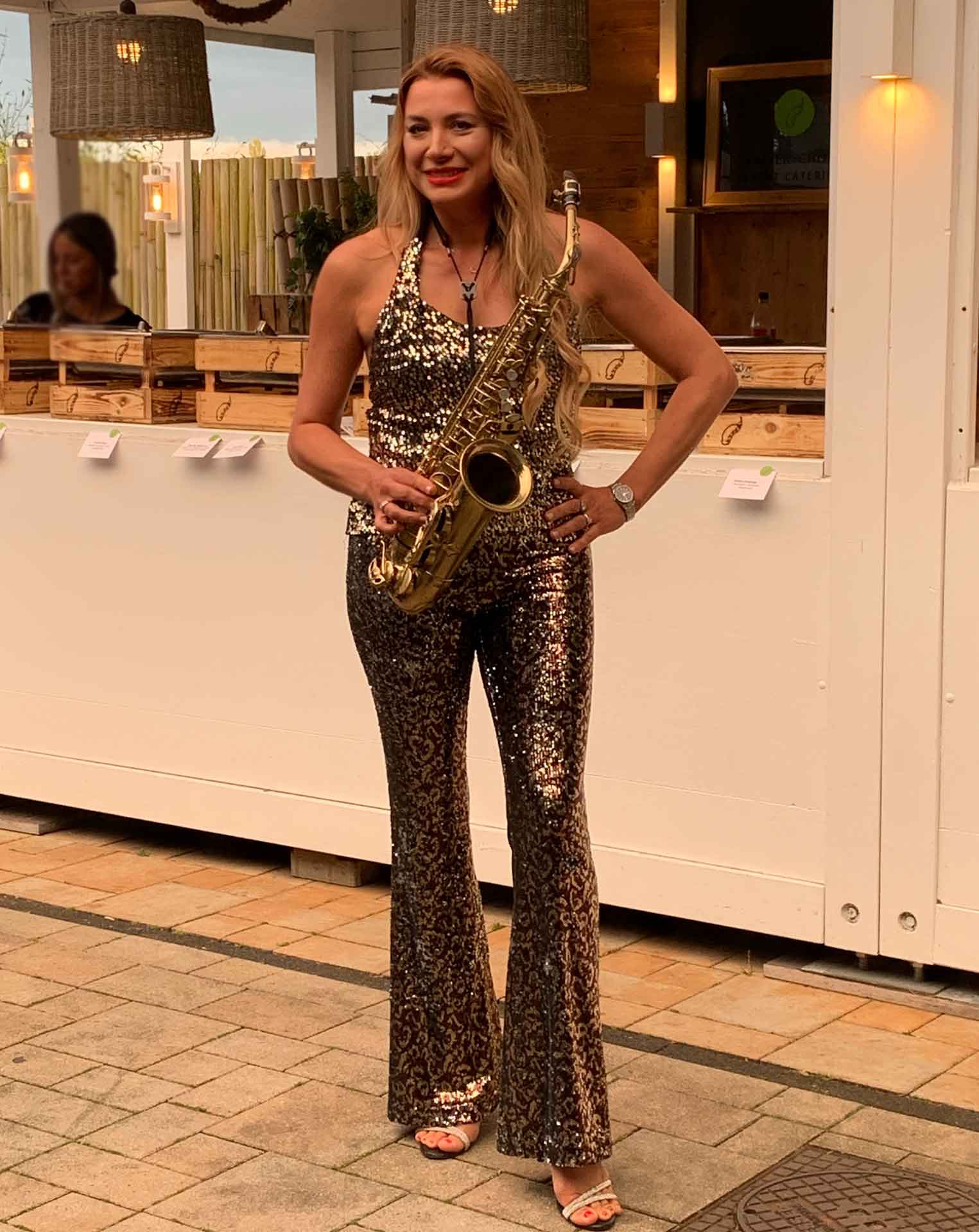 Saxophonist Natalie Marchenko in a golden outfit at a corporate after-fair event in Cologne